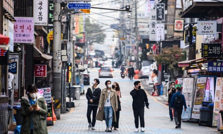 People walk on a street in Seoul