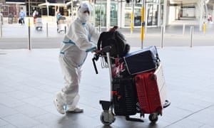 An international traveller dressed in protective clothing arrives Sydney airport