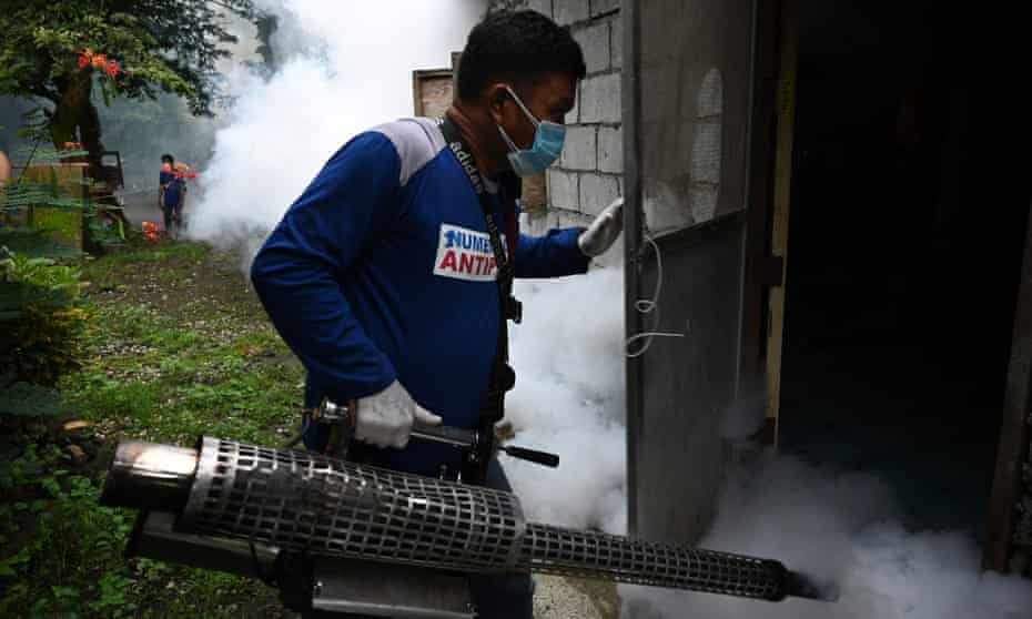 A municipal employee operates an insecticide fogging machine to kill mosquito larvae in a house in Antipolo, in the Philippine province of Rizal