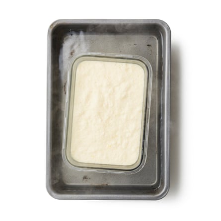 Pour the mix into the buttered dish (it should almost fill it to the brim), then sit the dish in the toasted tin.