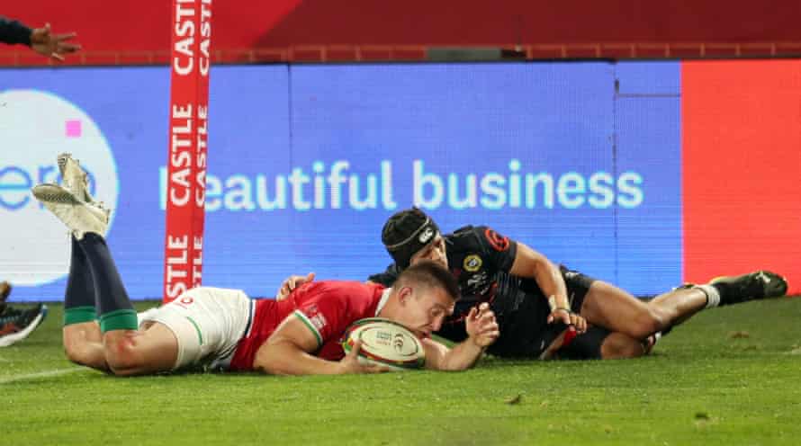 British and Irish Lions’ Josh Adams scores a try as Sharks’ Thaakir Abrahams attempts to make a tackle.