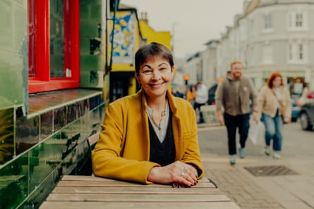 Lucas sitting at a wooden table outside what may be a pub on a busy Brighton street