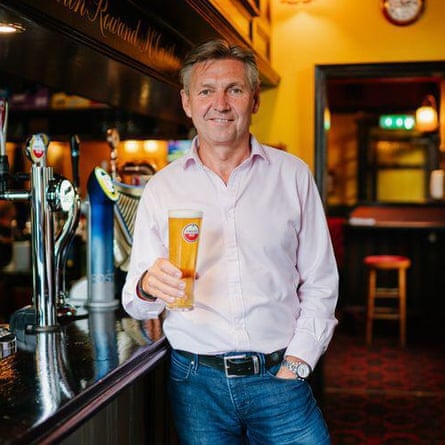 Philip Thorley holding a pint in front of a bar