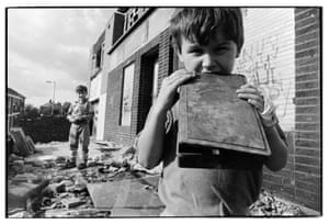 Children playing in the remains of the Scotswood post office after it went up in flames during riots, 1991.