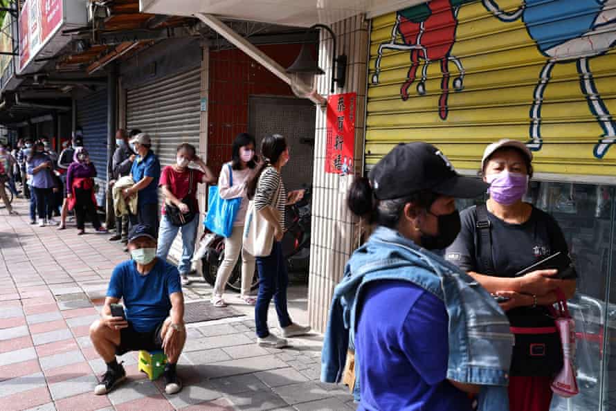 People wait to purchase Covid antigen tests at a pharmacy in Taipei.