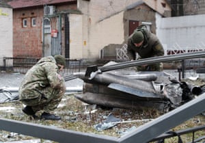 Police officers inspect the remains of a missile that fell in a Kyiv street