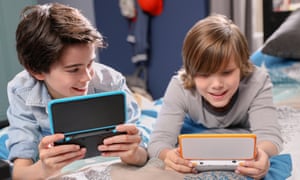 Nintendo 2DS XL portable games console in the hands of two boys.