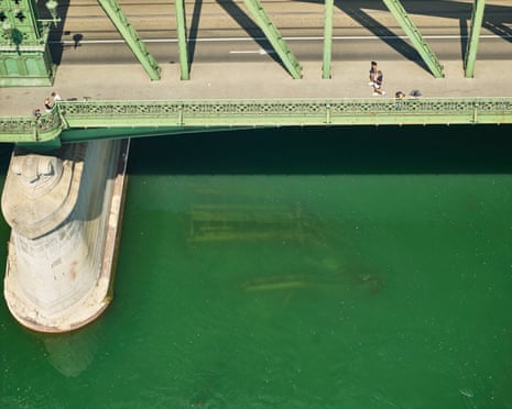 The remains of a bridge submerged in shallow water