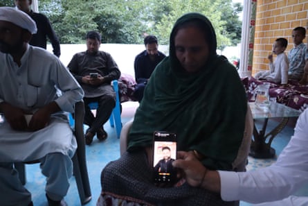 Rubina Kausar sits by a phone showing an image of her son Ahmed, 26.