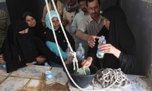 People line up to collect blessed water inside the shrine of Imam Mahdi.