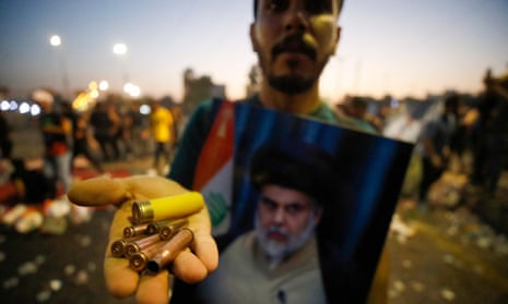 A supporter of Moqtada al-Sadr displays bullet casings and a spent shotgun shell in the Iraq capital, Baghdad.