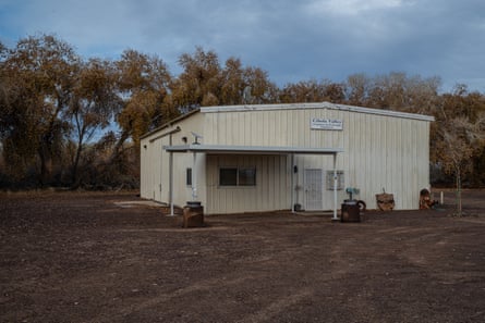 white building in an open space with trees in the background