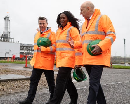 Douglas Alexander, Scottish secretary, Miatta Fahnbulleh, energy secretary, and John Healey walk through a gas terminal in bright orange coats provided by Shell.