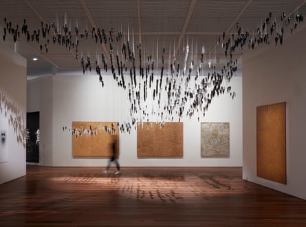 Interior room of gallery featuring suspended artwork from ceiling and on walls