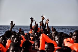 Migrants wait to be rescued as they drift in a boat