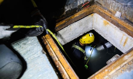 A diver enters a sewer to search for anti-government protesters trying to escape from the besieged Hong Kong Polytechnic University.