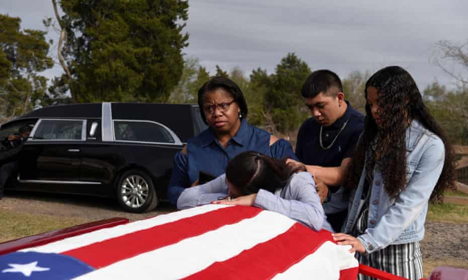 Lila Blanks is comforted by her friend Nikki Wyatt, her son Brandon Danas, 17, and her daughter Bryanna Danas, 14, as she reacts by the casket of her husband, Gregory Blanks, 50, who died from complications from Covid-19 in Texas, January 26, 2021. 