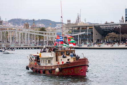 Small vessel bearing flags of many different countries sailing in harbour