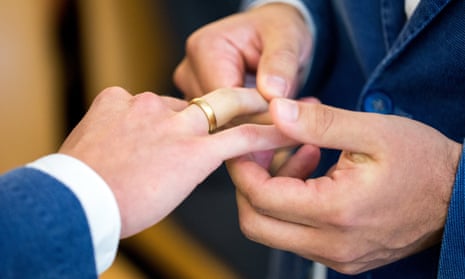 Two men exchange rings at a wedding ceremony in Munich.