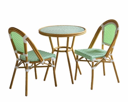 Two wooden chairs with white and green cushions and back rests with a herringbone pattern. The table in the centre has a green and white herringbone pattern top and a wooden circular frame.