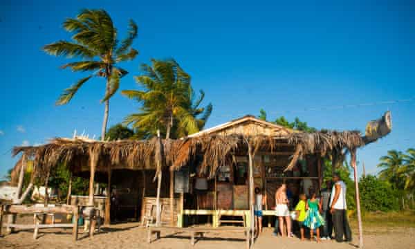 Locals and travellers at a bar and restaurant on Treasure Beach in St Elizabeth, Jamaica.