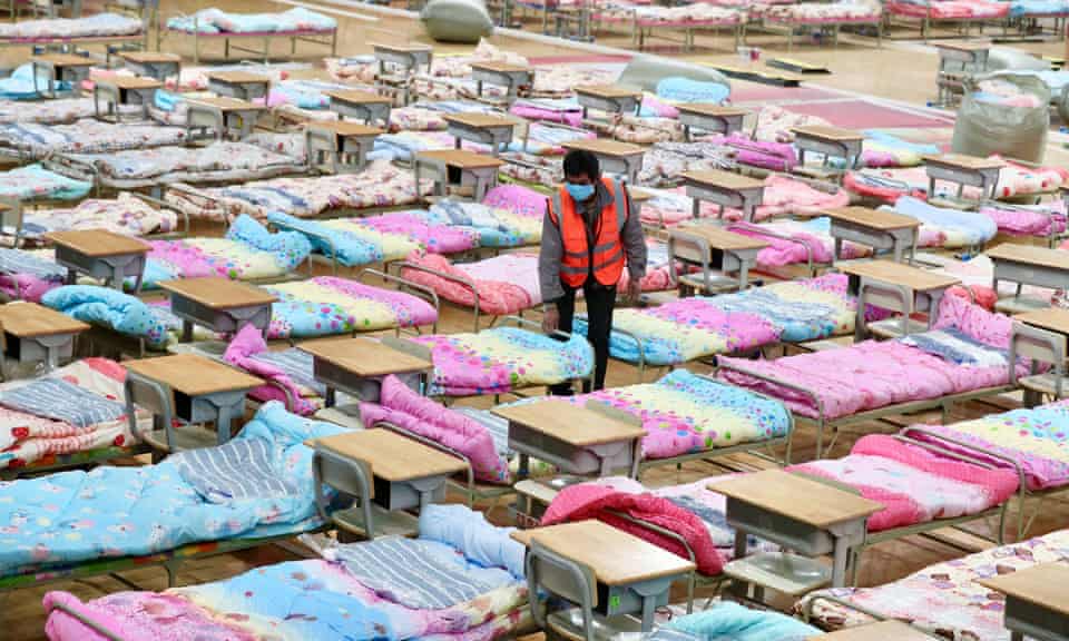 Beds laid out in a sports hall being converted into a makeshift hospital in Wuhan.