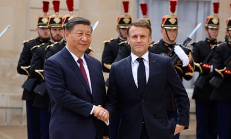 French President Emmanuel Macron (R) greets Chinese President Xi Jinping (L) upon his arrival at the Elysee Palace in Paris.