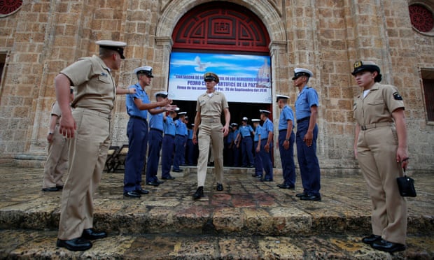 Members of the Colombian navy gather outside a church in Cartagena where the president, Juan Manuel Santos, will attend mass before signing a peace agreement with the Farc.