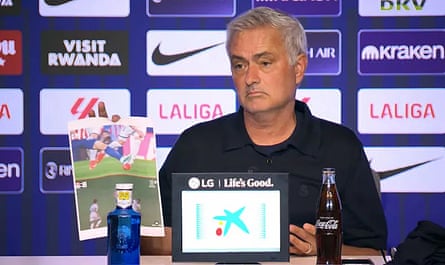 José Mourinho holding up an A4 paper showing two moments he thought were red cards in the Madrid derby.
