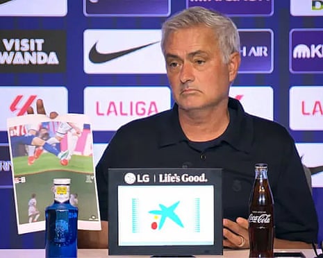 José Mourinho holding up an A4 paper showing two moments he thought were red cards in the Madrid derby