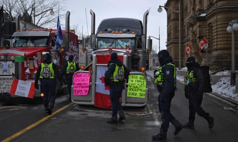 Police officers patrol Wellington Street in Ottawa as truckers continue their protest against Covid-19 mandates on Wednesday.