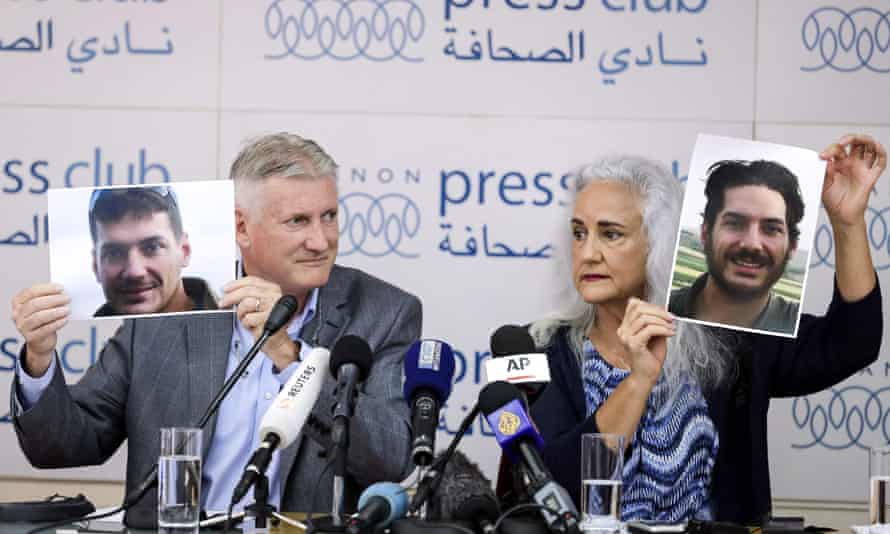 مارك وديبرا تايس ، والدا الصحفي الأمريكي أوستن تايس الذي اختطف في سوريا ، يحملان صورًا له خلال مؤتمر صحفي في بيروت عام 2017.