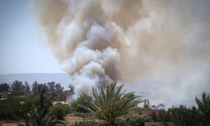 Heavy smoke rises above buildings in Espiaa, about 40km south of Tripoli