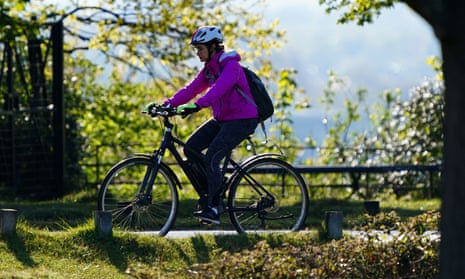 A cyclist on an e-bike rides through Richmond Park in London