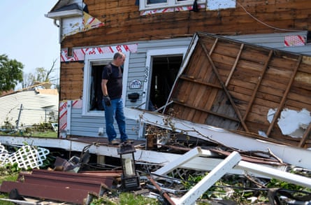 a man looking at a damaged home