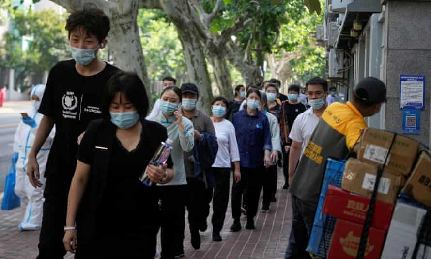 People line up for nucleic acid tests on a street, amid new lockdown measures in parts of Shanghai