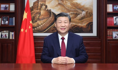 Xi Jinping sat at a desk with the Chinese flag behind him