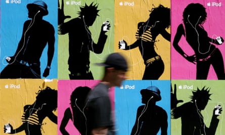 A pedestrian passes a wall covered with Apple iPod advertisements in 2005.