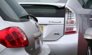 A Toyota Prius hybrid car behind a Toyota Auris at a car dealer