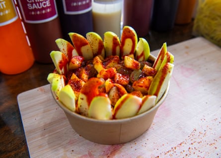 A bowl of fruit salad covered with a spicy topping