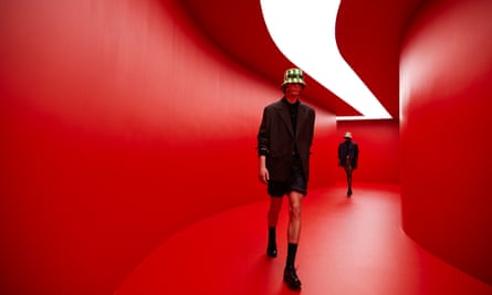 Models walking in the ‘tunnel-like underground club-cum-runway lit in devilish red’