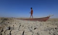 A boy walks on a boat on the dried bed of a part of Iraq's receding southern marshes.