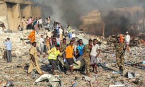 Men and Somalian soldiers rescue victims on the site of the explosion of the truck bomb in the centre of Mogadishu.