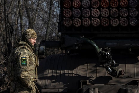 A Ukrainian serviceman stands next to a BM-21 Grad multiple launch rocket system in the Donetsk region.
