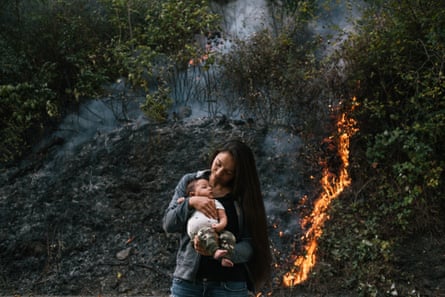 Crissy Robbins, daughter of Cultural Fire Management Council president Margo Robbins, holds her son Kenneth Koy-o-woh in front of the prescribed burn in Weithpec, California.