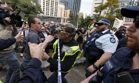 A Reclaim Australia supporter is held back by a volunteer as he lunges across police tape during a rally in Brisbane on 19 July. ,