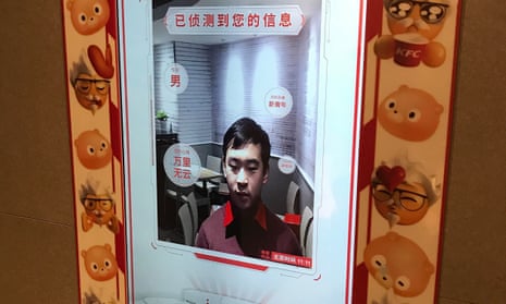 An employee a KFC in Beijing demonstrates the facial recognition ordering machine.