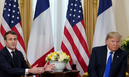 Emmanuel Macron in front of French and US flags gesturing towards a disinclined Donald Trump