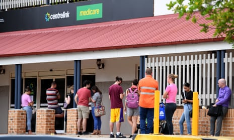 People  in a long queue outside a Centrelink office in Brisbane in March.