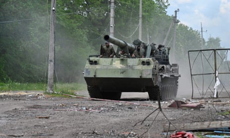 Ukrainian soldiers ride on a self-propelled howitzer on a road in Kharkiv region in Ukraine.